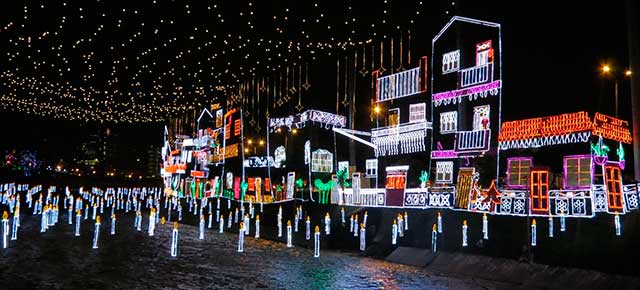 Foto nocturna de una ciudad junto al mar decorada por Navidad